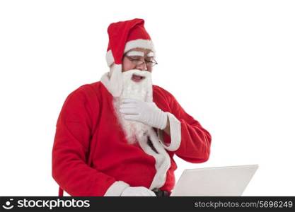 Cheerful Santa Claus using laptop over white background