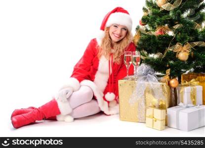 cheerful santa girl stand near the gift and New-year&rsquo;s tree. Copy text. Christmas greetings card