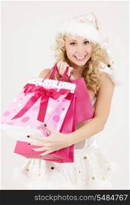 cheerful santa helper with pink shopping bags