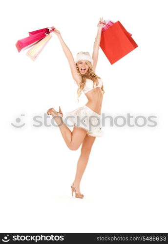 cheerful santa helper with shopping bags over white