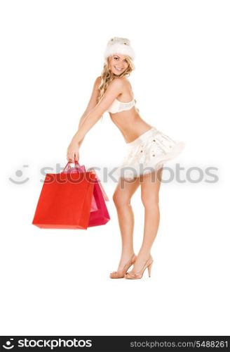 cheerful santa helper with shopping bags over white