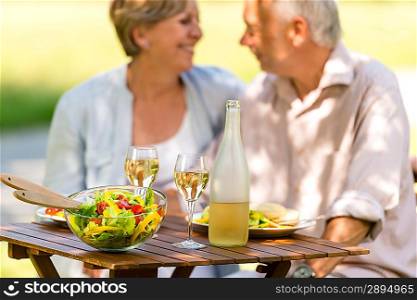 Cheerful senior citizens dating and eating outdoors