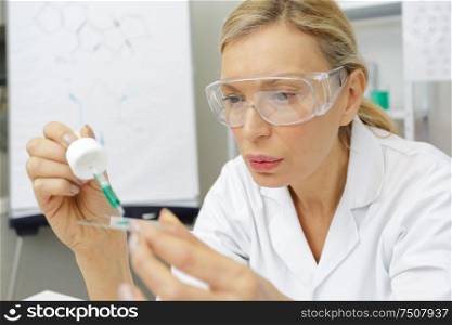 cheerful senior female scientist posing proudly at her lab