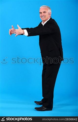 Cheerful senior man standing on blue background