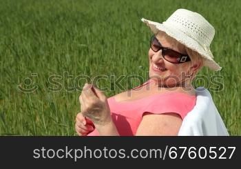 Cheerful senior woman in a wheat field