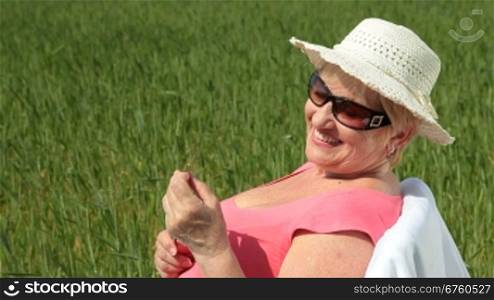 Cheerful senior woman in a wheat field