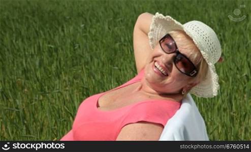 Cheerful senior woman outdoors, looking at the camera, smiling