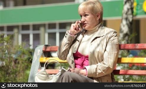 Cheerful Senior Woman Talking On The Phone Outdoors