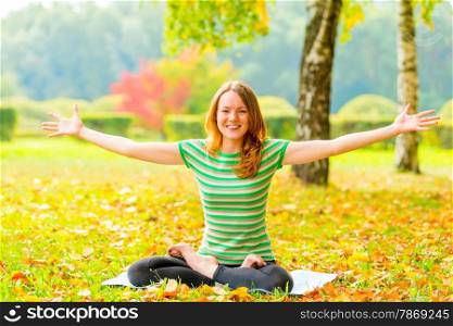 cheerful slim girl does yoga and laughs