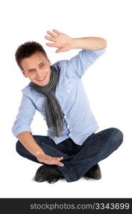 Cheerful smiling casual man sitting on the ground with legs crossed, isolated over white background