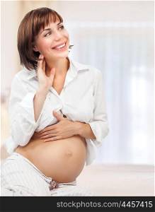 Cheerful smiling pregnant woman spending time at home, happy young family, beginning of new life, love and tenderness