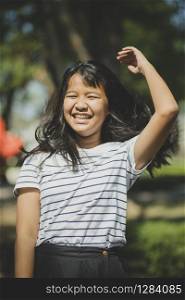 cheerful tan skin of asian teenager laughing in park