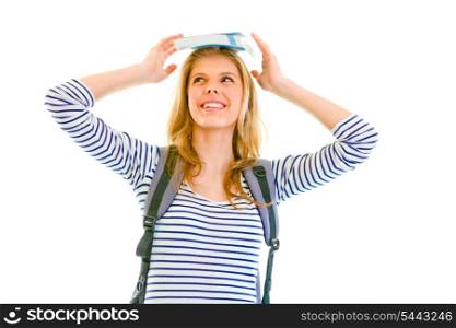 Cheerful teen girl balancing book on top of her head isolated on white &#xA;