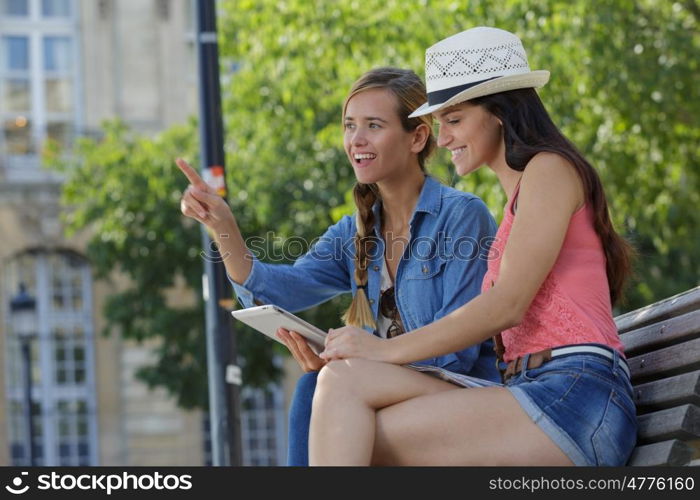 cheerful tourist female friends taking photos of themselves