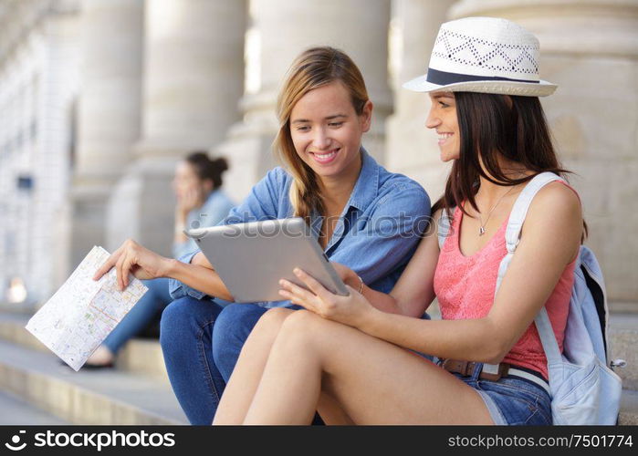 cheerful tourist female friends taking photos of themselves