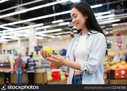 cheerful woman checking apple grocery store