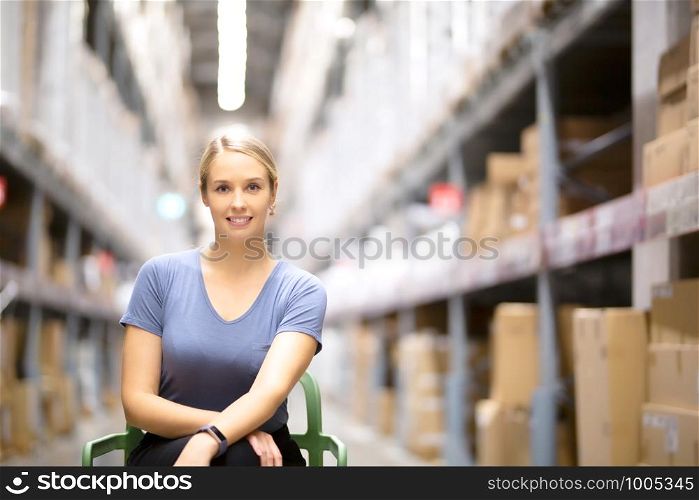 Cheerful woman customer looking at camera and sitting on chair while shopping in hardware store