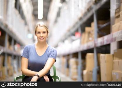 Cheerful woman customer looking at camera and sitting on chair while shopping in hardware store