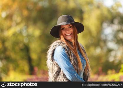 Cheerful woman having fun outdoors. Autumnal happiness idea. Happy cheerful young woman in black hat outdoor. Joyful attractive girl having fun in park.
