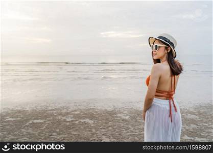 cheerful woman in bikini standing at the sea beach