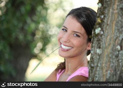cheerful woman leaning on a tree