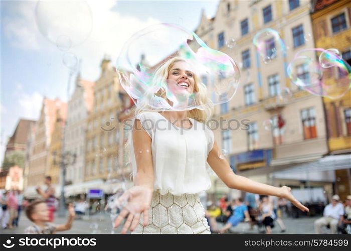 Cheerful woman looking through the huge bubble