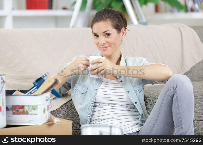 cheerful woman painting her new apartment takes a break