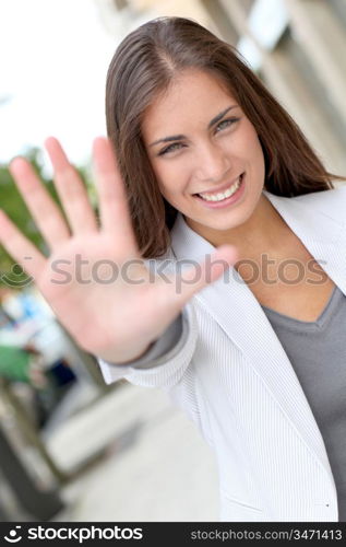 Cheerful woman showing hand to camera