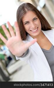 Cheerful woman showing hand to camera
