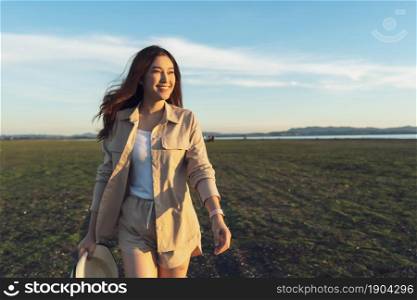 cheerful woman walk across the green field with sunlight