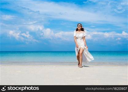 cheerful woman walking on the sea beach at Koh MunNork Island, Rayong, Thailand