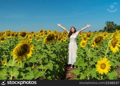 cheerful woman with arms raised and enjoying with sunflower field