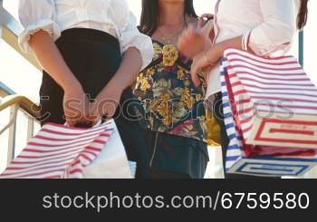 Cheerful women carrying shopping bags