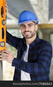 cheerful worker holdig a builders level