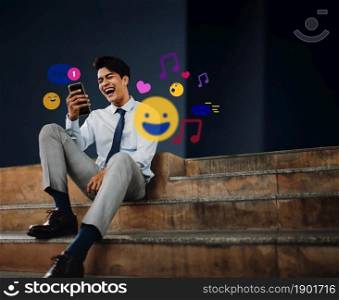 Cheerful Young Asian Businessman Using Mobile Phone in the City. Enjoying Social Media application. surrounded by many icons