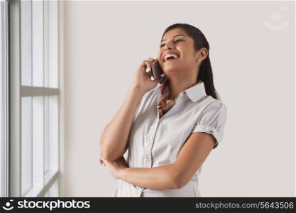 Cheerful young business woman enjoying the conversation on phone call