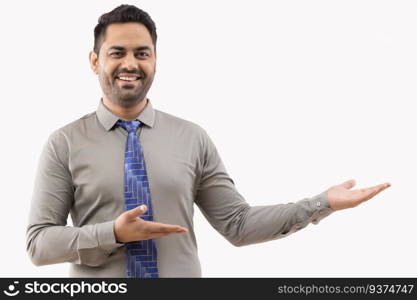 Cheerful young businessman pointing against white background
