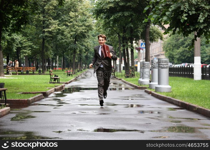 Cheerful young businessman walking on the street