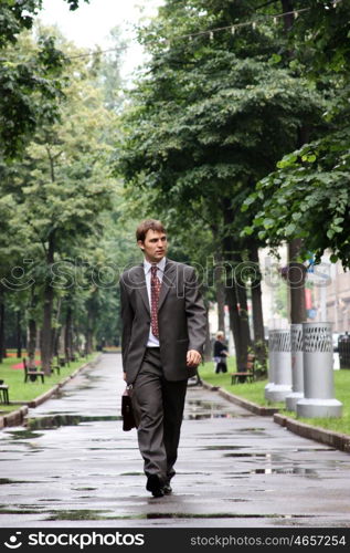 Cheerful young businessman walking on the street
