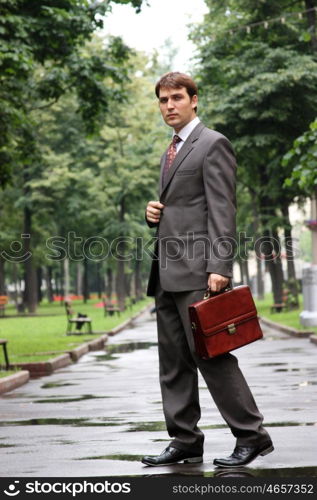 Cheerful young businessman walking on the street