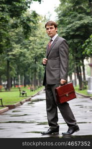 Cheerful young businessman walking on the street