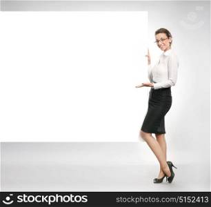 Cheerful, young businesswoman holding an empty board