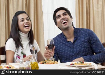 Cheerful young couple enjoying the meal at restaurant
