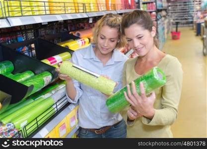 cheerful young couple of friends shopping in hardware store