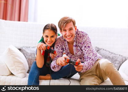 Cheerful young couple playing console&#xA;