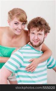 Cheerful young couple portrait blonde girl and bearded guy on gray background,