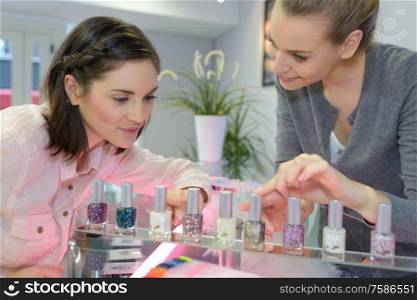 cheerful young girl choosing nail polish