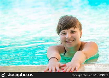cheerful young girl spends time in the pool