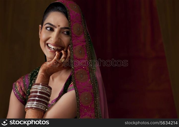 Cheerful young Indian bride looking away