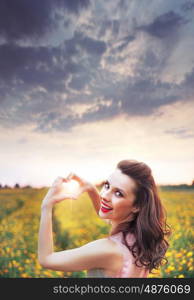 cheerful young lady making a heart sign